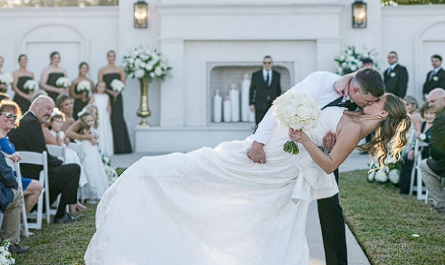 Alexis and Tristan sharing a dip kiss at the end of their ceremony