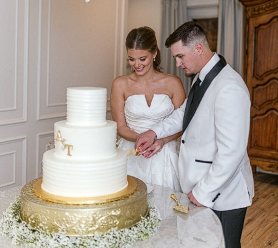 Alexis and Tristan cutting their wedding cake together