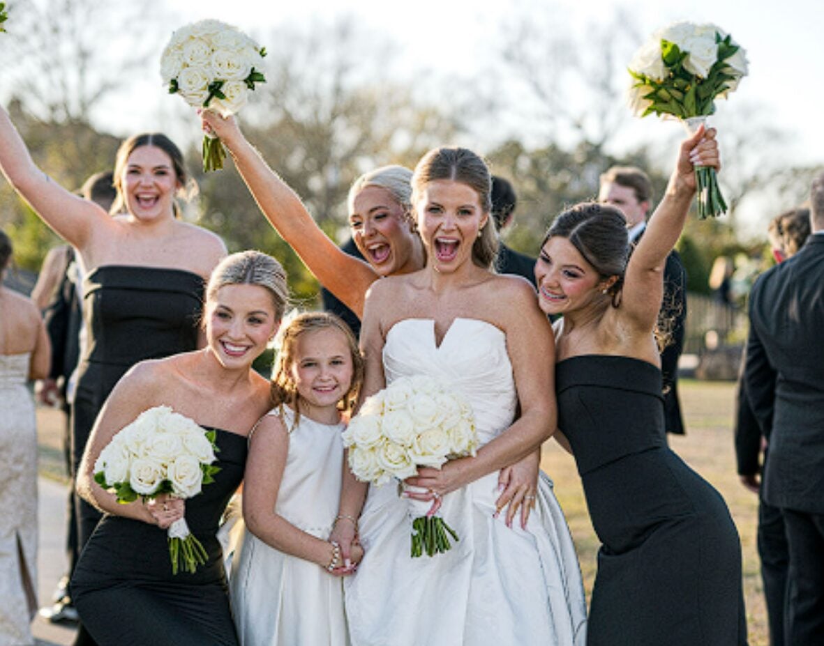 Alexis celebrating with her bridesmaids and flower girl holding white bouquets