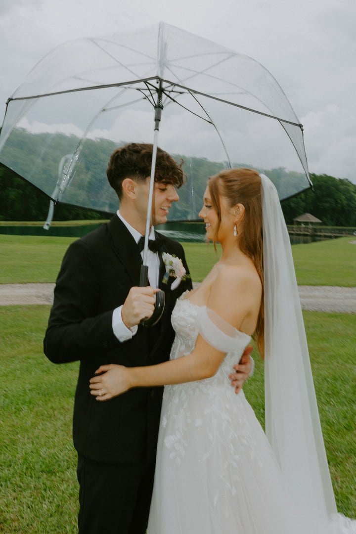 Avery and Timothy sharing a moment under a clear umbrella on their Alexandria, Louisiana wedding day