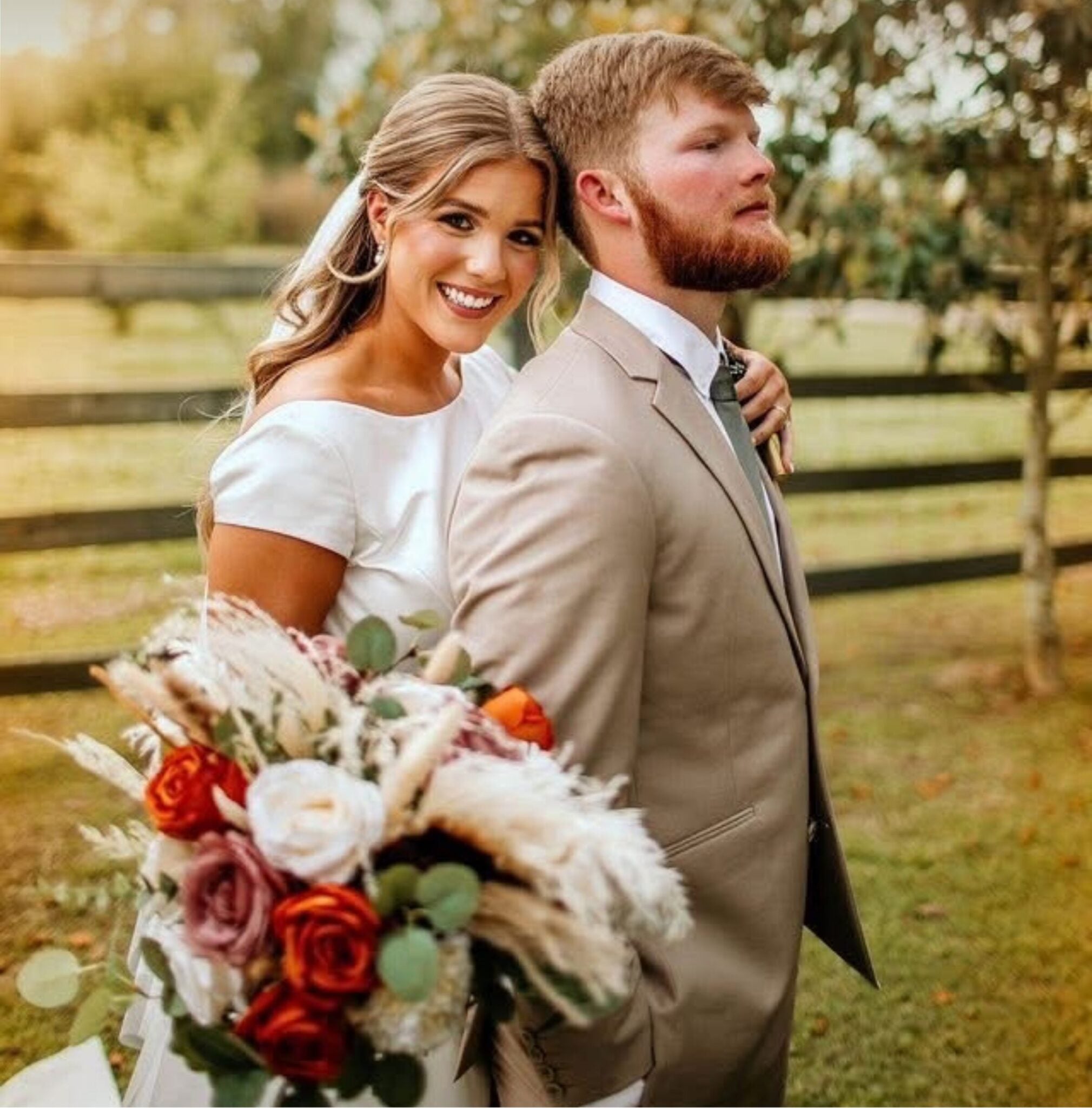 Cydney and Jaden posing together with a burnt orange boho bouquet at The Berry Barn in Amite, Louisiana
