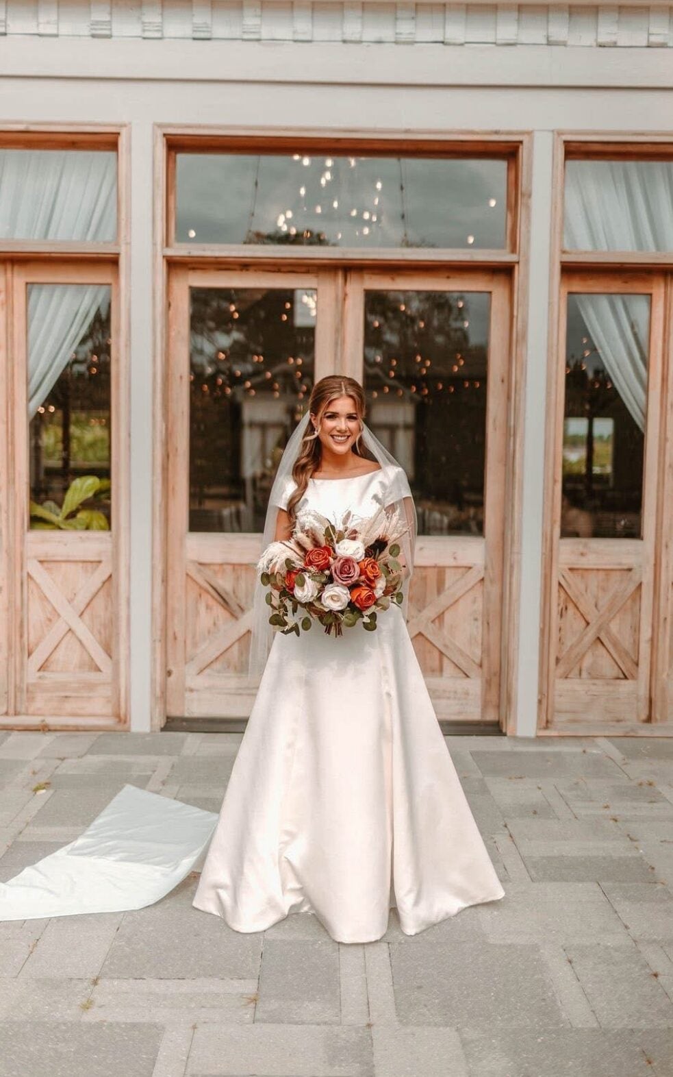 Cydney in her wedding gown at the doors of The Berry Barn